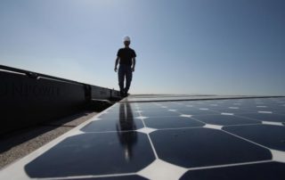 Man Walking By Solar Panels